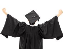 Graduate student in graduation gown with raised hands isolated on white background, rear view